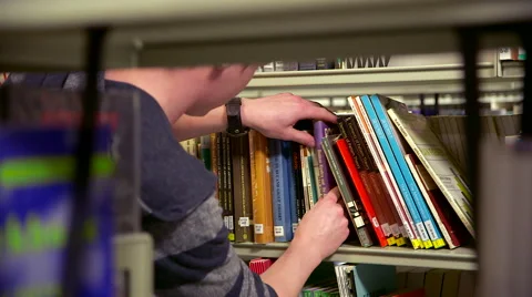 Student Looking Through Books in a Library Stock Footage 61636830