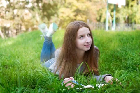 Student lying on grass and thinking Stock Photos