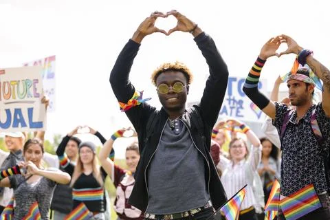 Student making heart shape with hands at gay pride festival Stock Photos