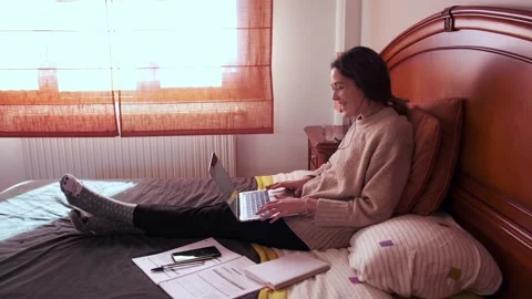 Student making a video call with her laptop lying on bed. Stock Footage 145811428