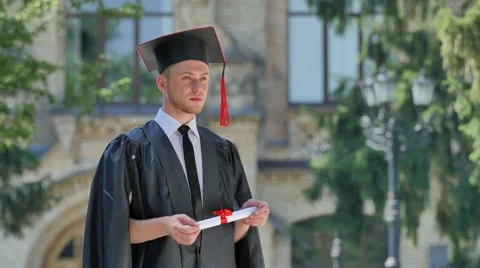 Student in Mantle Has Got His Diploma Thinking Standing in Alley Outside the Stock Footage 64812459