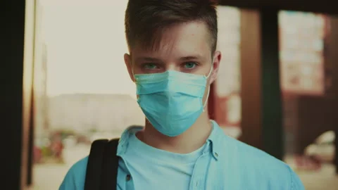 Student in a mask watching at the motion camera. Close-up portrait of young man Stock Footage 141558171