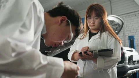 Student Measuring Engine Dimensions While Colleague Records Data in Mechanical Stock Footage 302186460