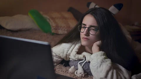 Student night in bed, is studying on a laptop, camera tracking Stock Footage 149998414