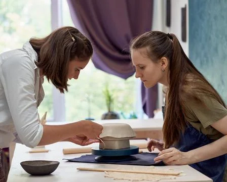 Student observing work of master of clay modeling with concentration Stock Photos