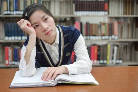 Student with open textbook deep in thought Stock Photos