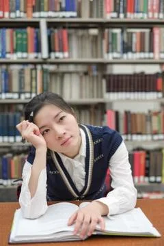 Student with open textbook deep in thought Stock Photos