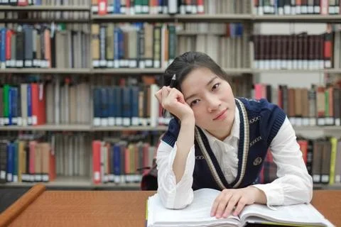 Student with open textbook deep in thought Stock Photos