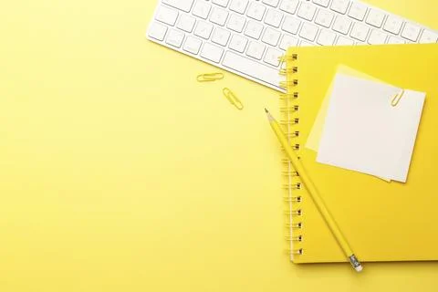 Student or freelancer workspace with keyboard, coffee, notepad, pen and pencils Stock Photos
