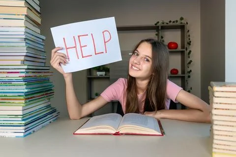 Student overwhelmed by study work holding a help sign. A student holding a sign Stock Photos