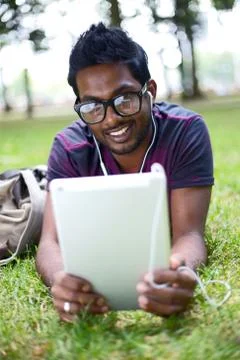 Student in the park using his tablet computer Stock Photos