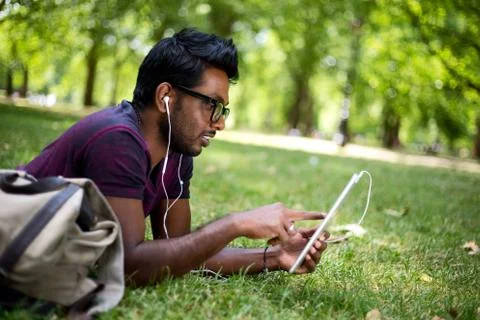 Student in the park using his tablet computer Stock Photos