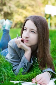 Student with pen thinking on grass Stock Photos