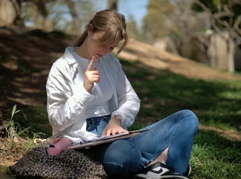Student with a pen thinking over her homework Stock Photos
