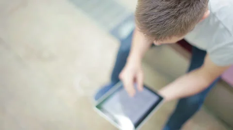 Student playing with electronic device, high angled Stock Footage 39343255