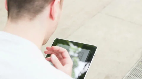Student playing with electronic device, reading ebook Stock Footage 39343199