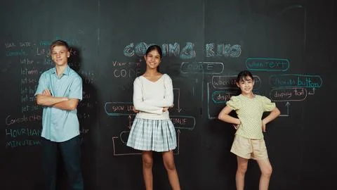Student pose at camera while standing at blackboard with code. Edification. 库存照片