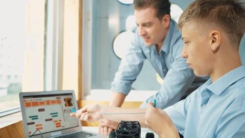 Student present coding program and car model to skilled teacher. Edification. Stock Photos