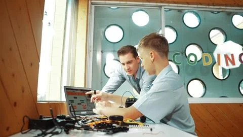 Student present coding program and car model to skilled teacher. Edification. Stock Photos