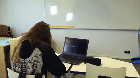 Student programming on a laptop with AI in a classroom Видео 345479997