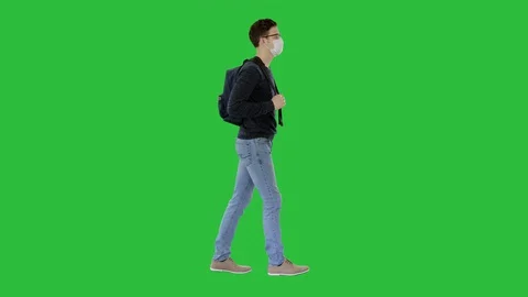 Student in protective masks walking with backpack on a Green Screen, Chroma Key. 스톡 동영상 129694334