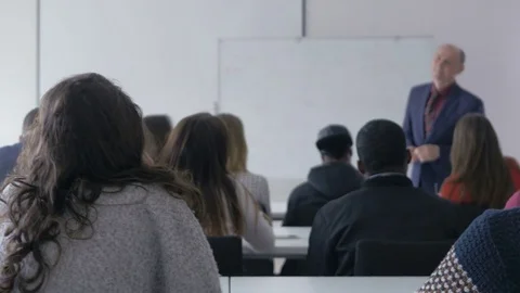 Student raising a hand and asking a question in a classroom Stock Footage