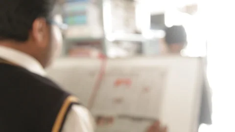 A student reading the newspaper in a school library. Stock-Footage 114479723