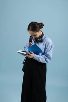 Student Reading Notebook on Blue Background 스톡 사진