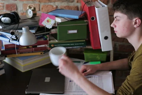 Student reading notes and drinking coffee in desk Stock-Footage 41139120