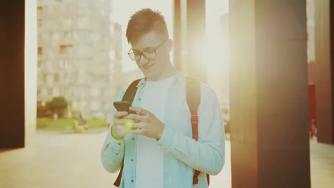 Student reading something good at the smartphone. Portrait of young handsome Stock Footage 141557408
