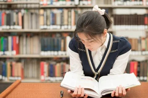 Student reading a textbook in library Foto stock