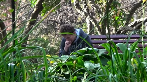 The student reads the lecture notes. Sitting on a park bench. Stock Footage 54833362