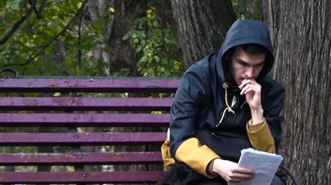 The student reads the lecture notes. Sitting on a park bench. Stock Footage 54833450
