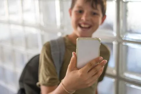 Student resting on the school and playing with a mobile phone Stock Photos