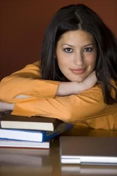 Student resting on stack of books Foto stock