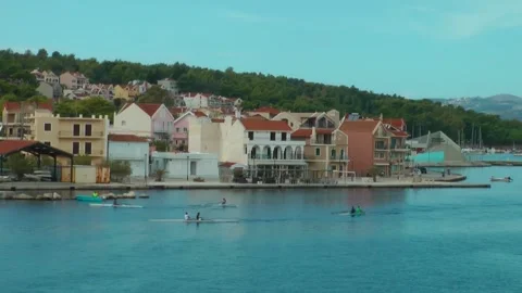 Student rowing teams training against the backdrop of the Argostolion waterf Stock Footage 314662498
