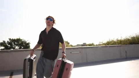 Student runs with suitcases during relocation to a new city and home Stock Footage 346365034