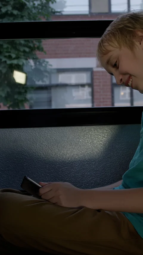 A Student on school bus on his device driving home from class Stock Footage 337220129
