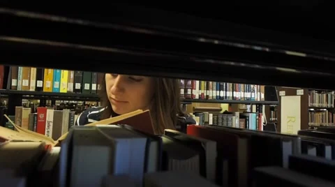 Student searching for a book at the library Stock Footage 46947760