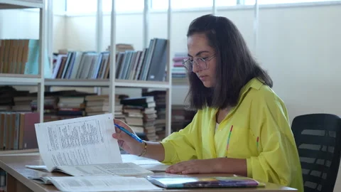 Student sits in the library and studies Video stock 244951151