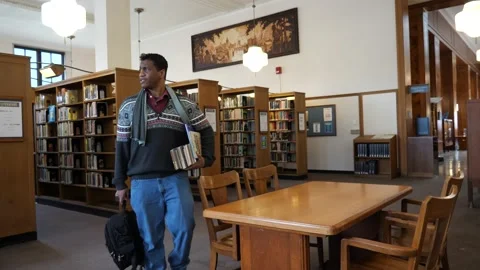 Student sits at table in library Video stock 171344180