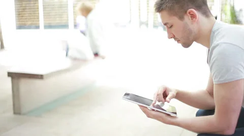 Student sitting on the bench and reading on electronic device Stock Footage 39343286