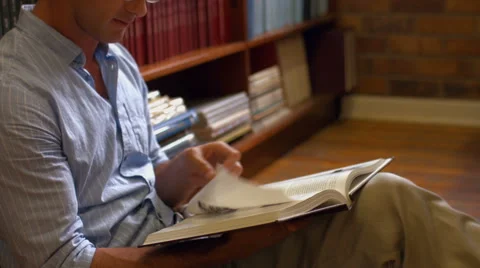 Student sitting on floor in library reading Video stock 47473546