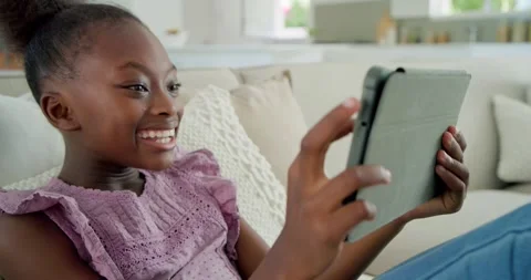 Student sitting on sofa tapping greyfolio tablet animating learning icons Stock Footage 337400395