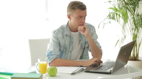 Student sitting at table and using laptop Video stock 27692074