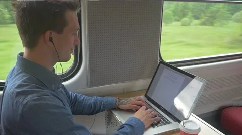 Student sitting on train while using a laptop to do work Stockbeeldmateriaal 51832675