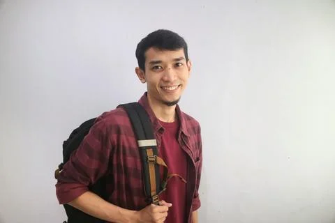 A student smiles confidently while carrying backpacks Stock Photos