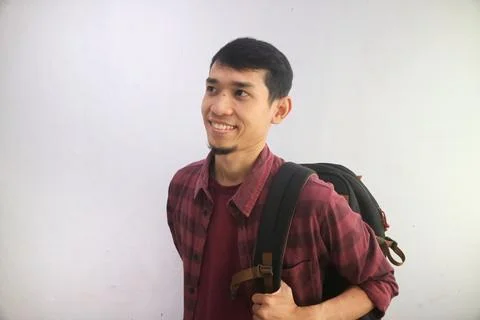 A student smiles confidently while carrying backpacks Foto stock