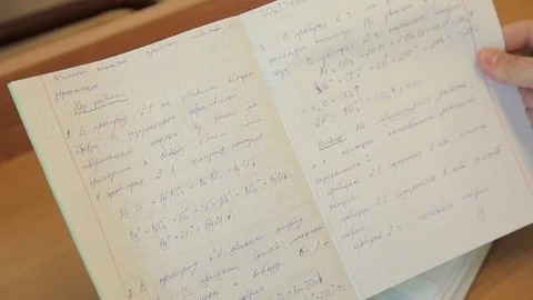 The student solves equations  in the notebook Stock Footage 72197078