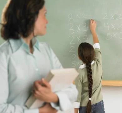 Student solving arithmetic on the chalkboard Stock Photos